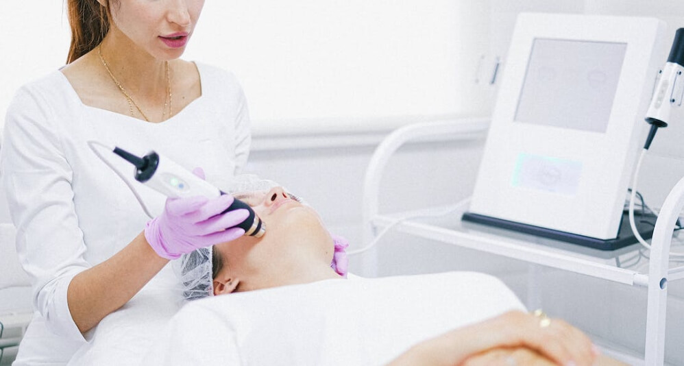 의사가 환자 얼굴에 피부레이저 시술중