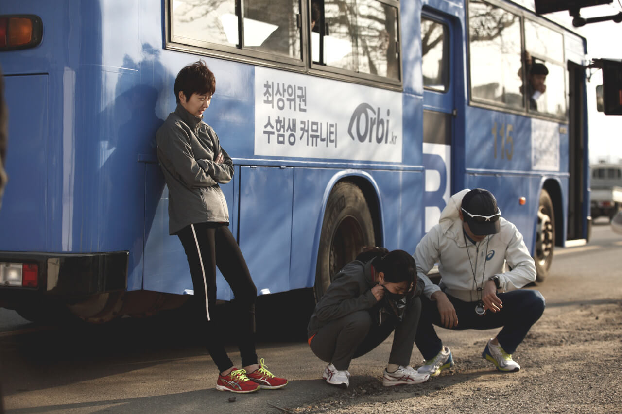 버스를 타고 멀미해서 토하는 만복과 그 곁을 지키는 코치와 수지 선배