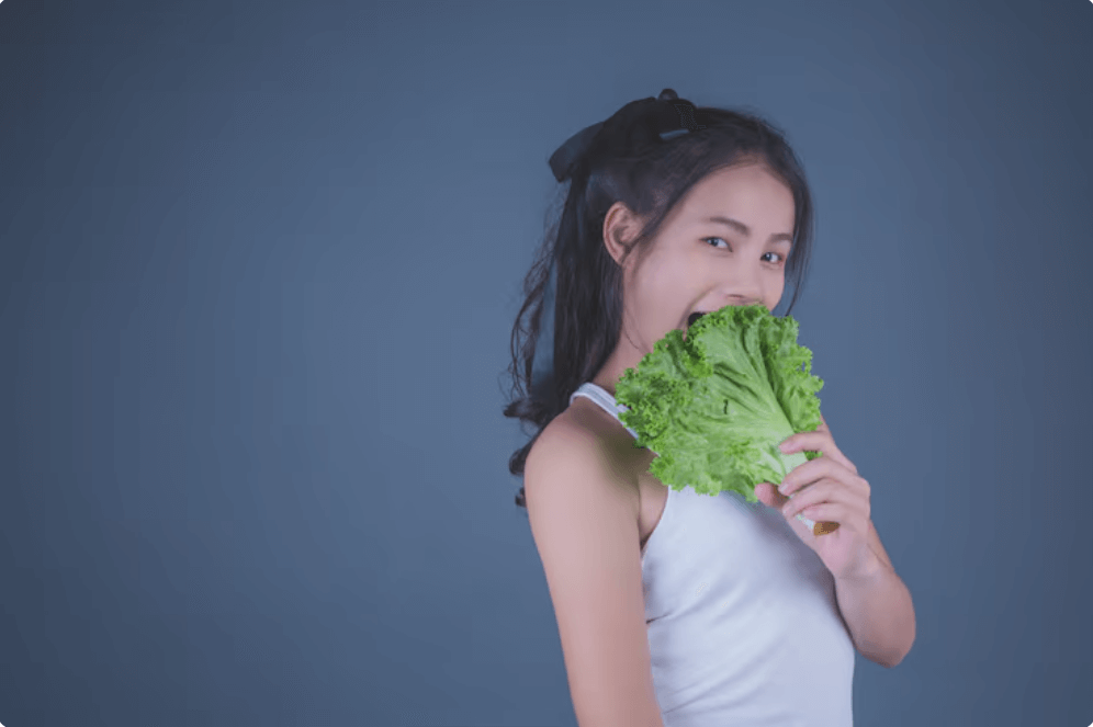 상추를 입에 넣고 있는 여성의 모습