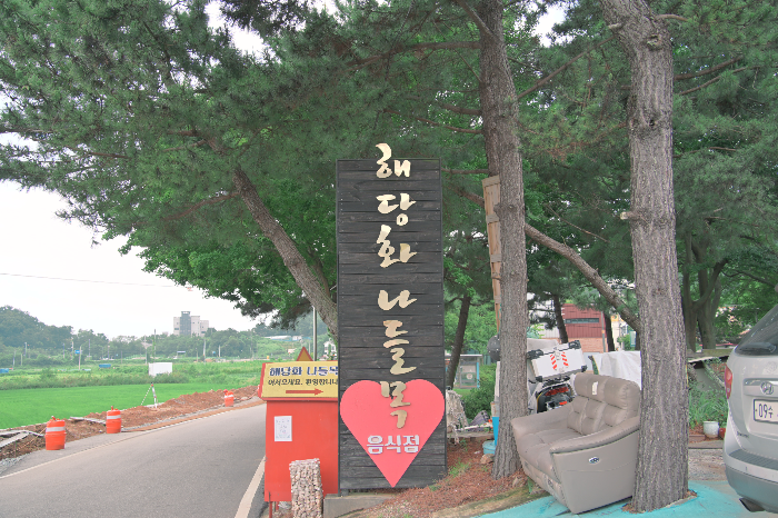 검은 바탕에 금색 글씨로 해당화 나들목이라고 쓰인 입간판