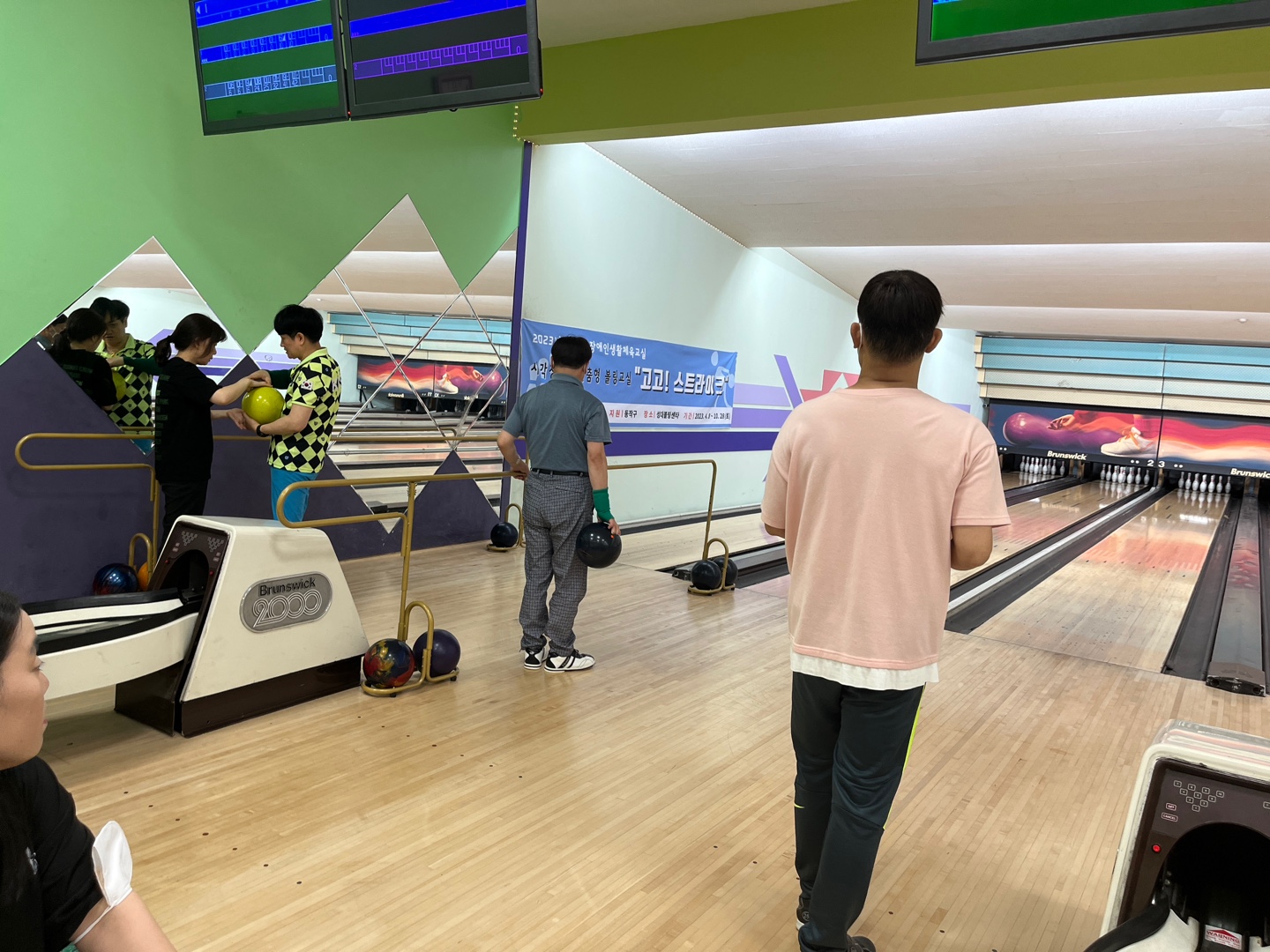 사진설명; 강사의 설명을 듣고 볼링 순서를 기다리는 참여자 모습