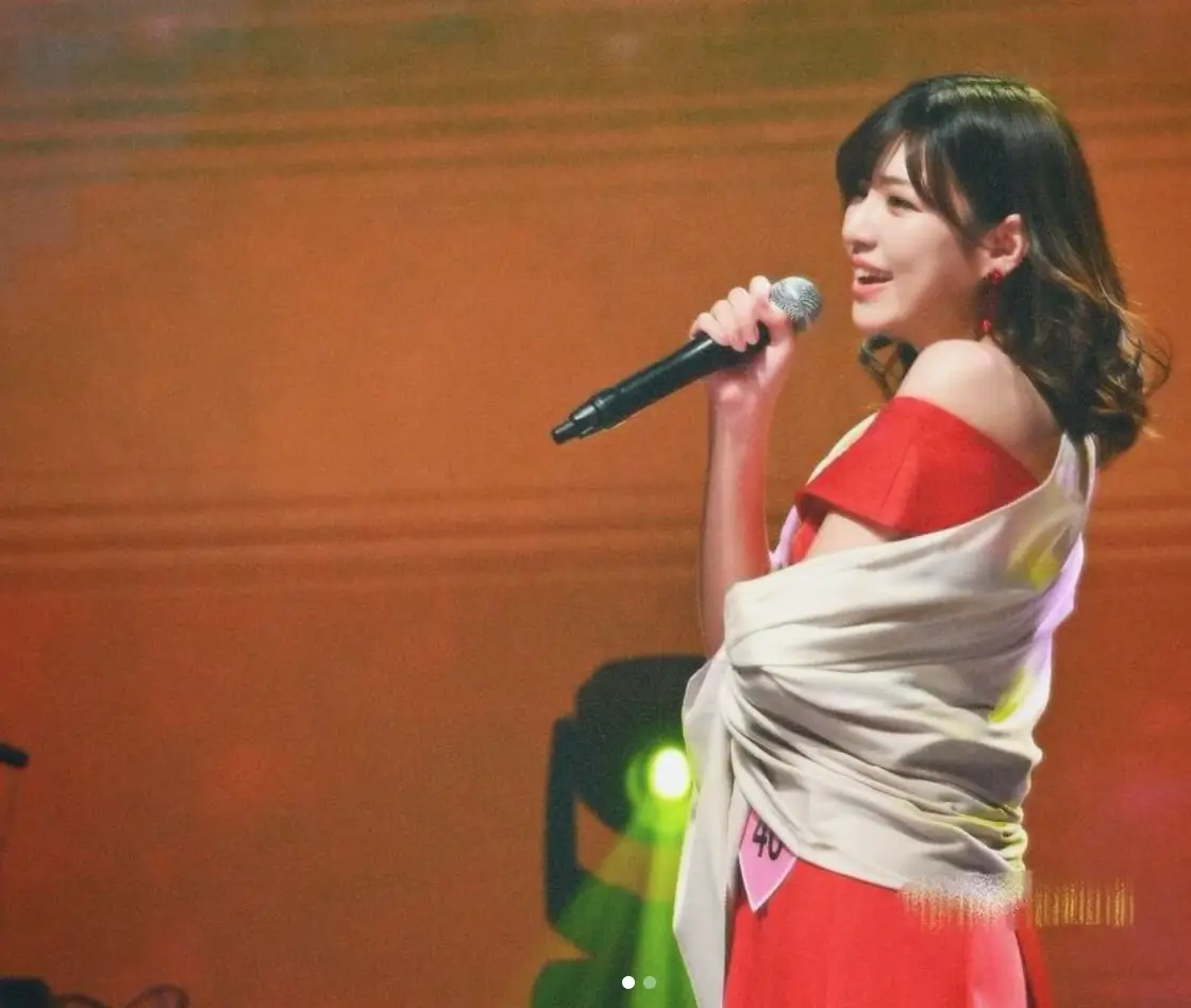 한일-붉은 무대 위 붉은 옷에 흰색 숄을 어깨에 두루고 노래하는 후쿠다 미라이