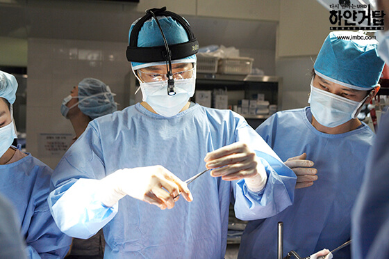 드라마 하얀 거탑에서 김명민이 수술 장면에서 의료진들과 함께 집중하고 있는 모습