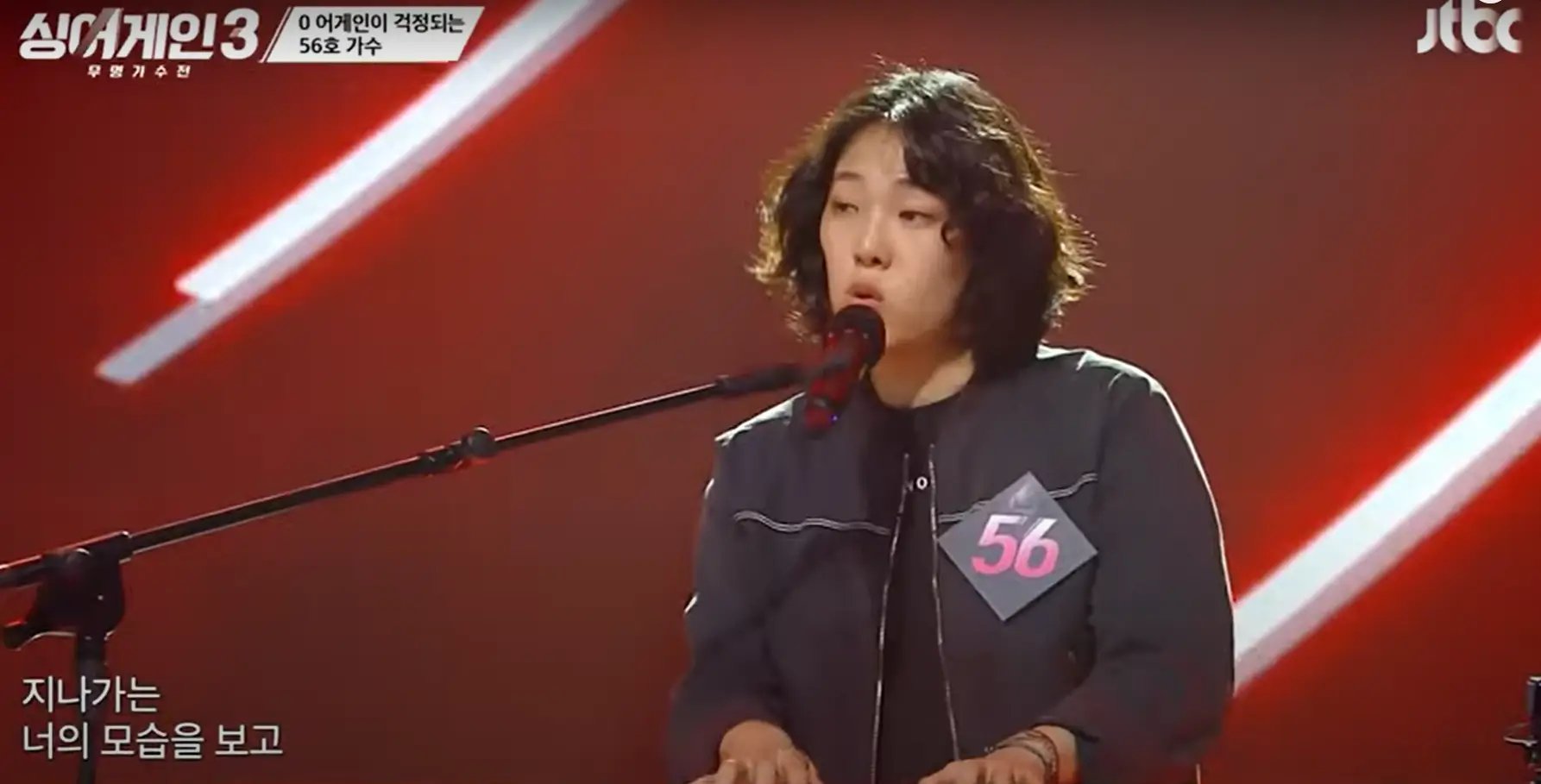 싱어게인 3- 스탠딩 마이크 앞에서 검은색 자켓에 56번 번호표를 달고 건반을 치며 노래하는 56호