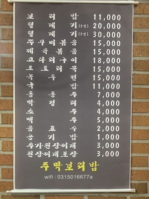 갈색-벽에-짙은-갈색에-흰색-글씨로-적혀있는-메뉴-안내판