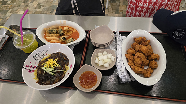 씨랄라 워터파크 푸드코트 식사. 짜장면, 떡볶이 튀김 세트, 치킨과 음료가 함께 제공되어 가족 단위 이용객이 즐기기 좋은 구성이다.