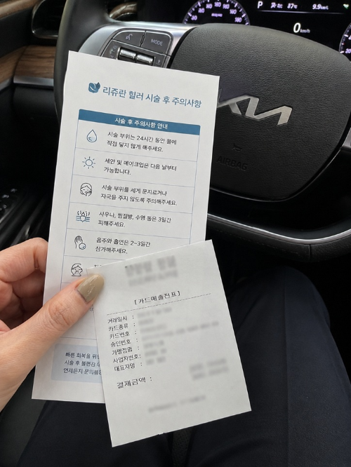 기아 자동차 운전대 앞에서 손에 들고 있는 리쥬란 힐러 시술 후 주의사항 안내문 종이와 카드 매출전표 내돈내산 영수증 인증 사진