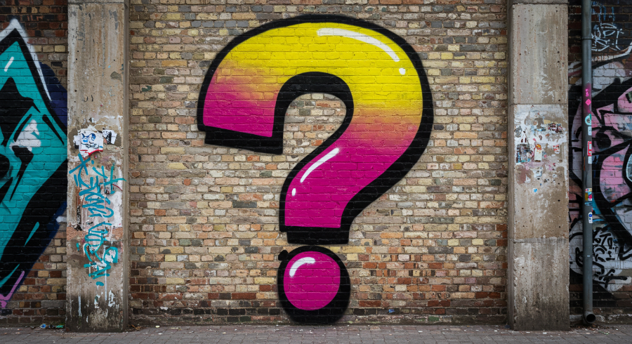 Colorful question mark graffiti on brick wall symbolizing curiosity about new smartphone technology