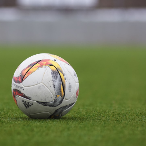 축구장 잔디위에 멈춰있는 아디다스 축구공