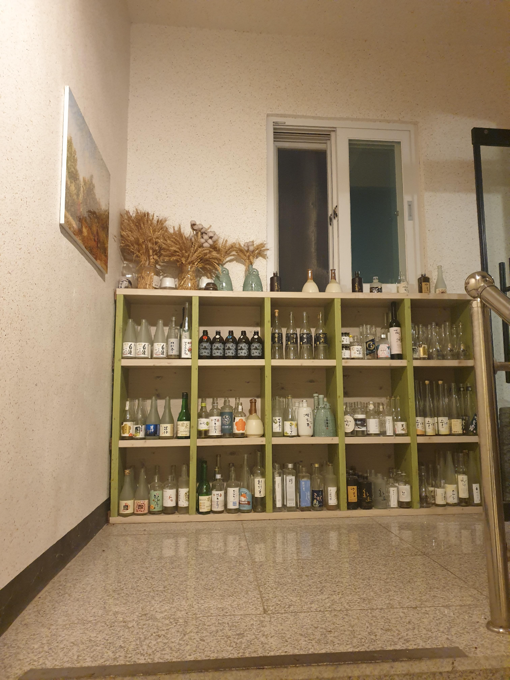 진열장에 빈 술병이 가득하다. 술병의 종류가 다양하다.