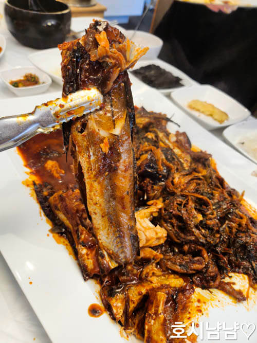 코다리덕장 코다리조림 근접샷, 집게로 코다리 살을 들어 올린 장면