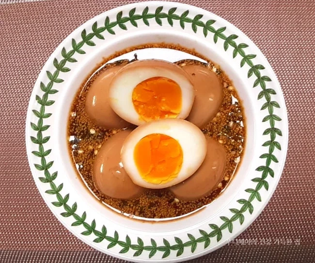 숙성된-다이어트-계란장을-그릇에-담고-위에-올려진-계란-1개를-반으로-잘라-노른자가 보이게-놓은-모습