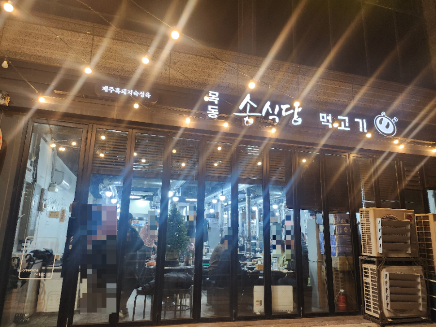 조명켜진 목동 송식당 먹고기 간판과 매장 전경