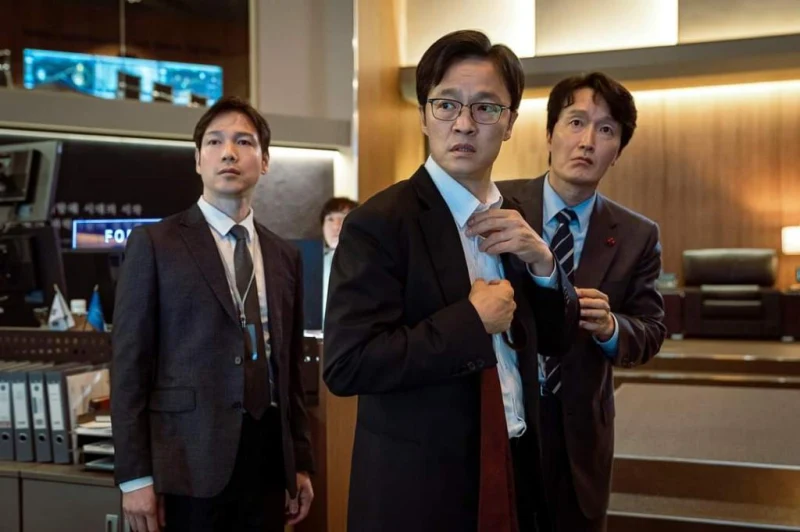 우주센터를 배경으로 검은 양복에 넥타이를 메려는 영화 더 문의 장관 조한철