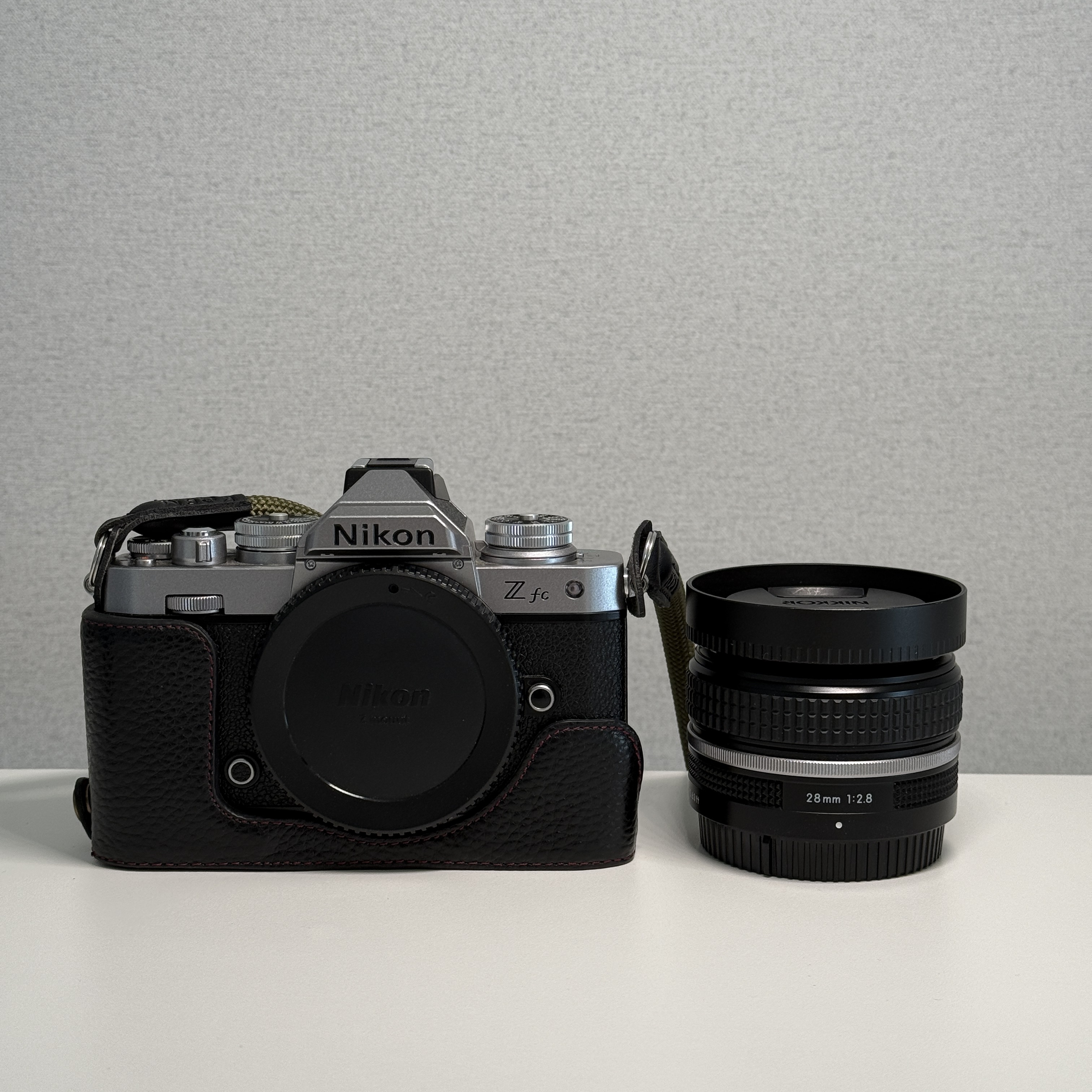 Nikon Z fc 바디와 NIKKOR Z 28mm f/2.8 SE 장착 모습을 담은 제품 사진