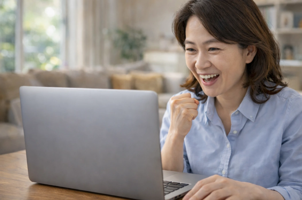 노트북으로 휴면예금과 보험금 환급 여부를 조회하며 기뻐하는 40대 여성