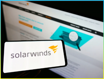 웹사이트 앞 화면에 미국 소프트웨어 회사 SolarWinds Inc. 로고가 있는 스마트폰을 들고 있는 사람. 스마트폰 화면에 초점을 맞추고 있음