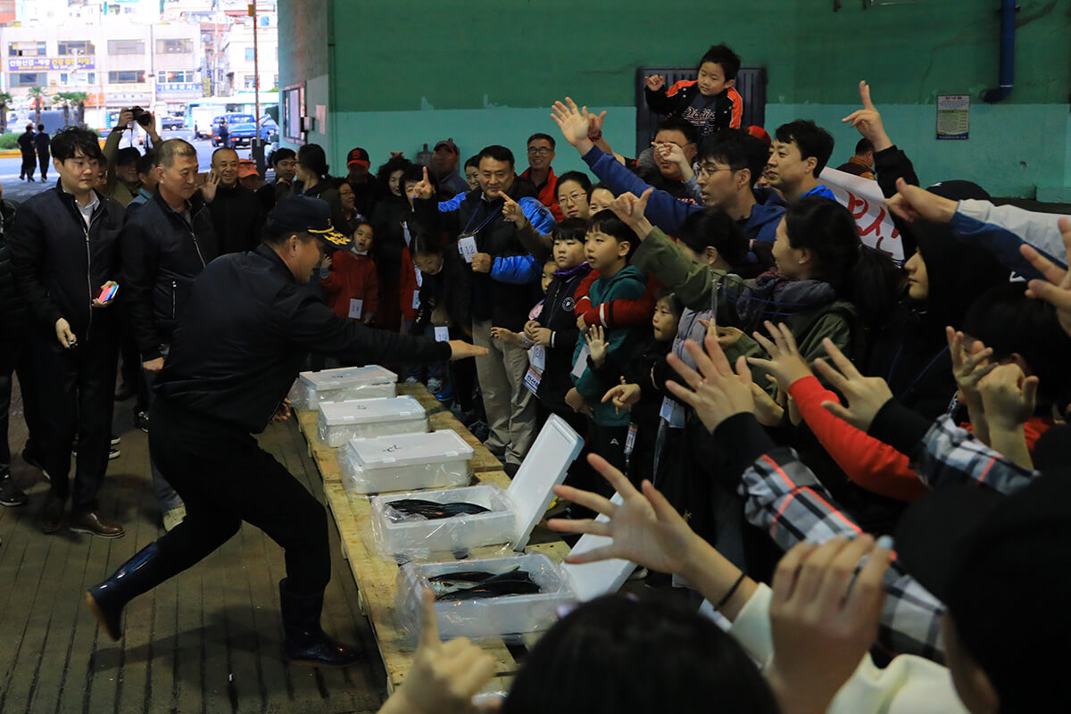 경매사를 향해 손을 드는 사람들