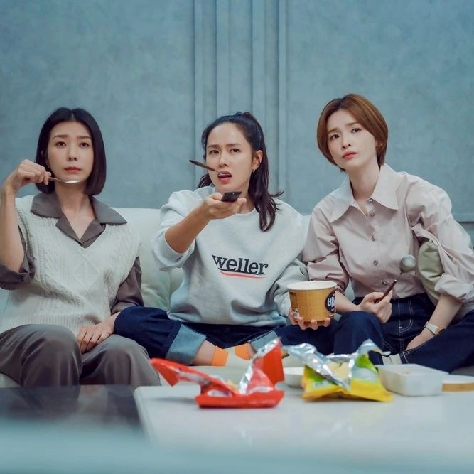드라마 주인공 세명이 과자를 먹으며 뭔가를 보는 모습