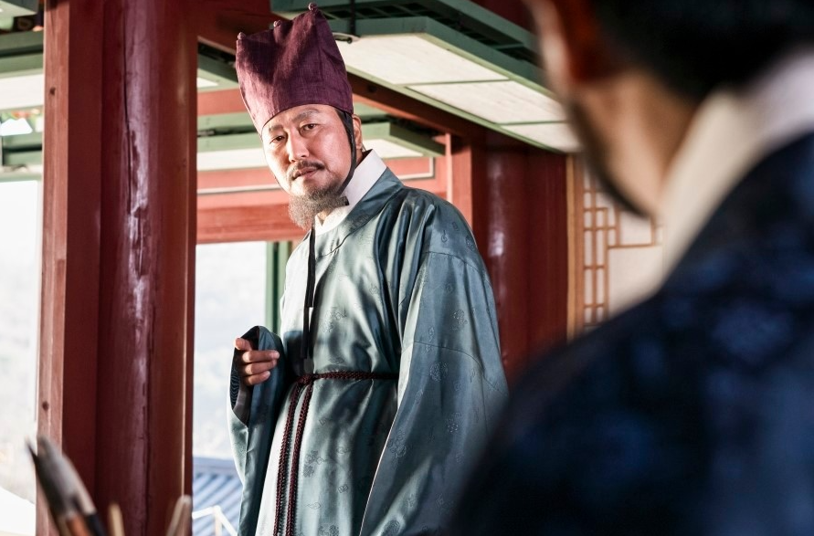 조선시대 관리 복장을 한 내경이 누각에서 누군가를 바라보는 장면, 앞쪽으로 다른 인물의 뒷모습이 함께 담겨 있다