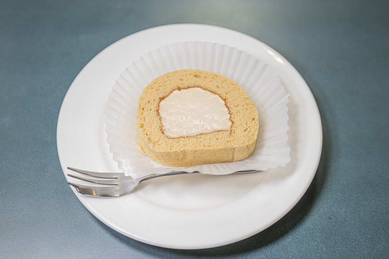 Kashikan Hashidate: a slice of cream-filled roll cake and a fork on a white plate.