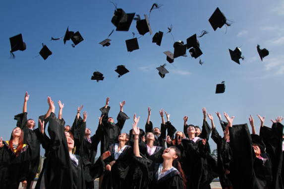 졸업한 대학생들이 사각모를 던지는 사진