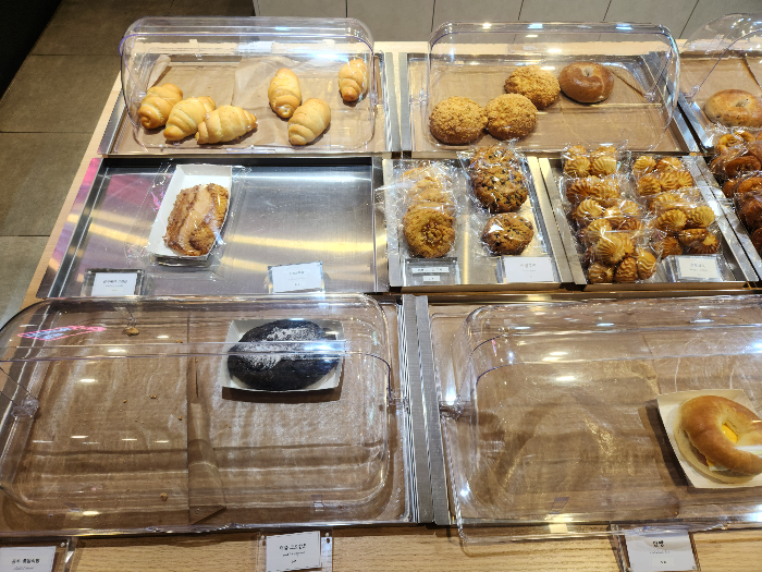 크럼블&amp;#44; 먹물 크로칸트&amp;#44; 팥빵이 진열대에 진열되어 있다