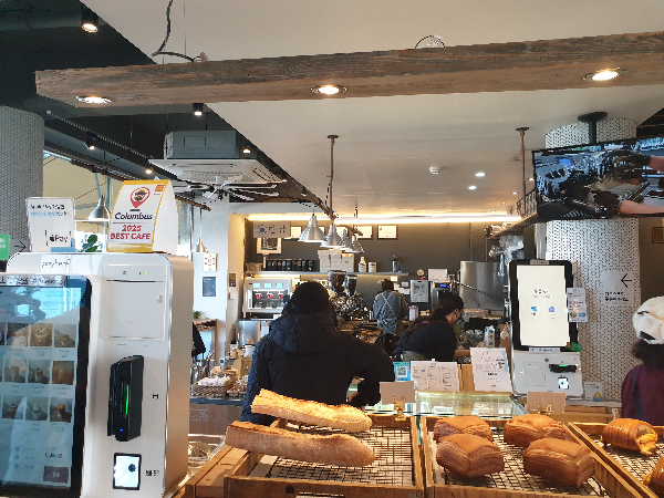 좌측 키오스크가 보이고 우측 빵 진열대가 있다.
