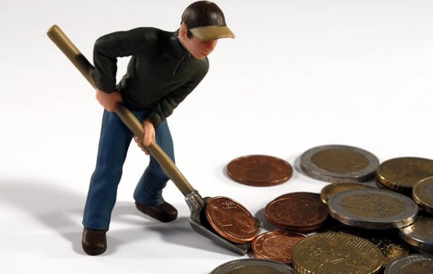 동전들과 그것을 삽으로 담고 있는 피규어