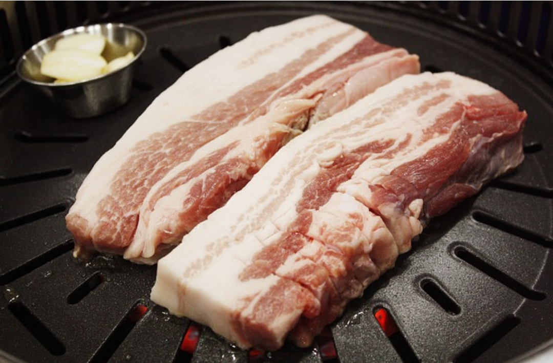 불판에 삼겹살이 놓여져 있다.