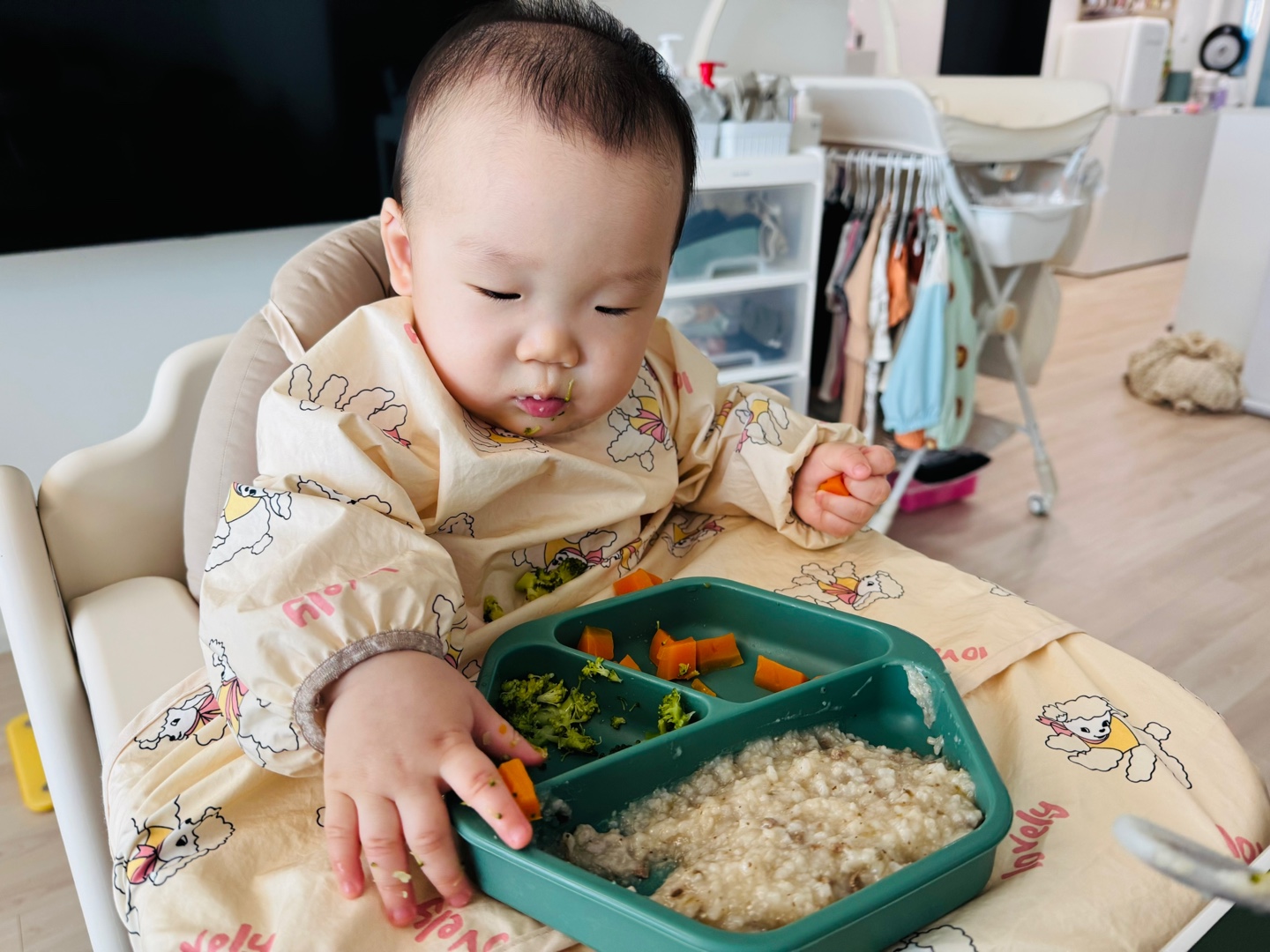 당근스틱을 손에 들고 식판을 바라보는 찬솔이