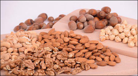 다양한 견과류가 쌓여있는 나무 접시