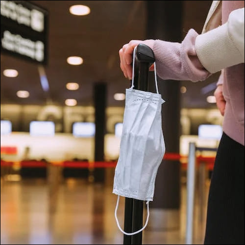 공항에 여행가방과 마스크를 들고 온 여성