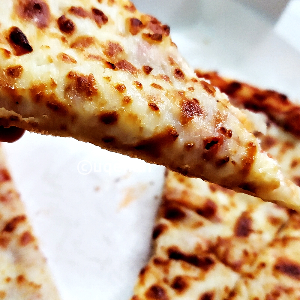 코스트코 치즈 피자의 옆모습이다. 치즈가 도톰하게 올라가져 있다.