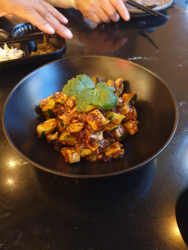 바질이 올라가 있는 오이무침. 고추가루에 묻힌 듯 보인다.