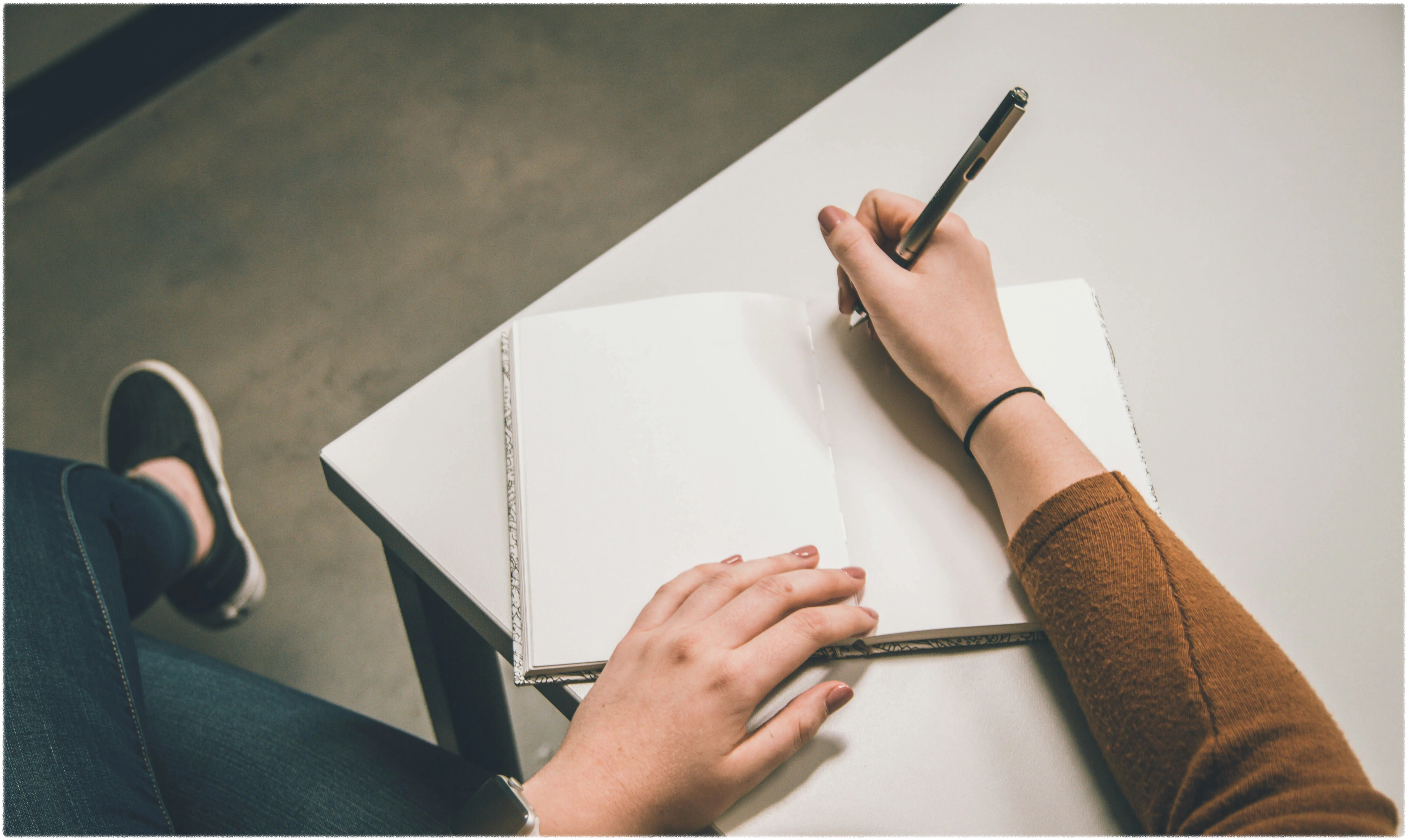 흰노트에-글을쓰고-있는-여성