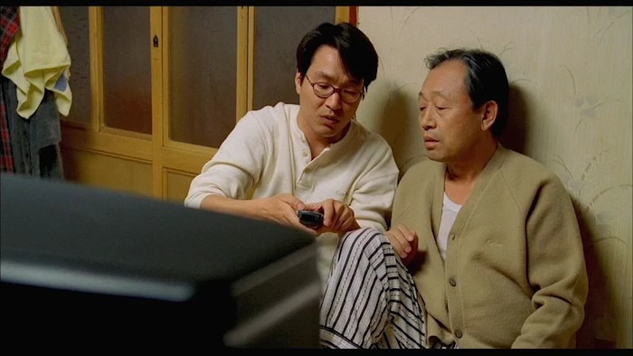 불치병을 앓고 있는 정원(한석규) 가 아버지에게 리모컨 조작법을 설명하고 있는 장면