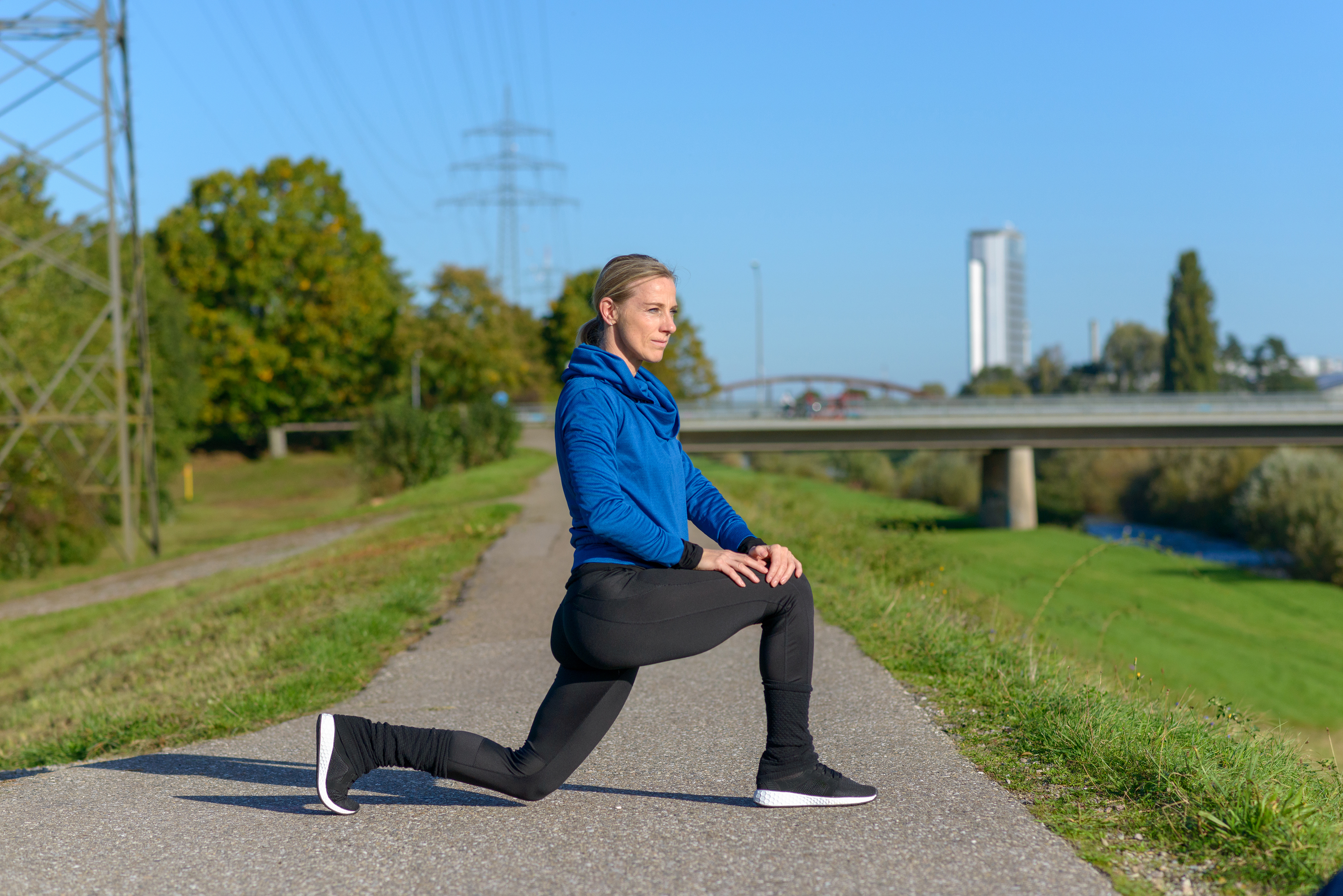 야외 산책로에서 워밍업 스트레칭 중인 중년 여성｜무릎 보호를 위한 걷기 전 준비 운동