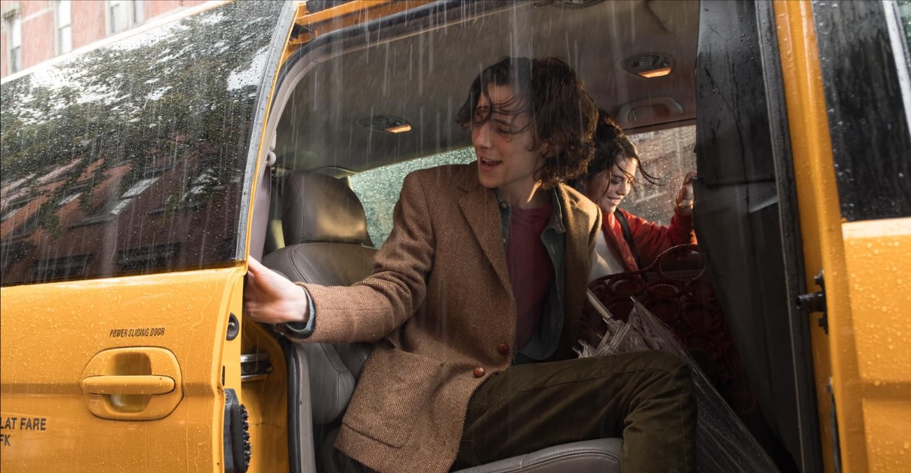 레이니 데이 인 뉴욕 티모시 샬라메 스틸컷 – 비 내리는 뉴욕 택시 안에서 문을 열고 있는 개츠비 장면