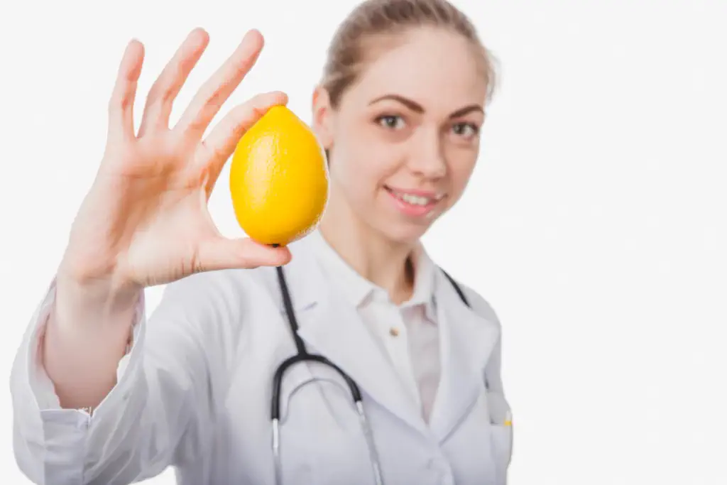 심장 모양의 레몬과 혈압계를 들고 있는 사람