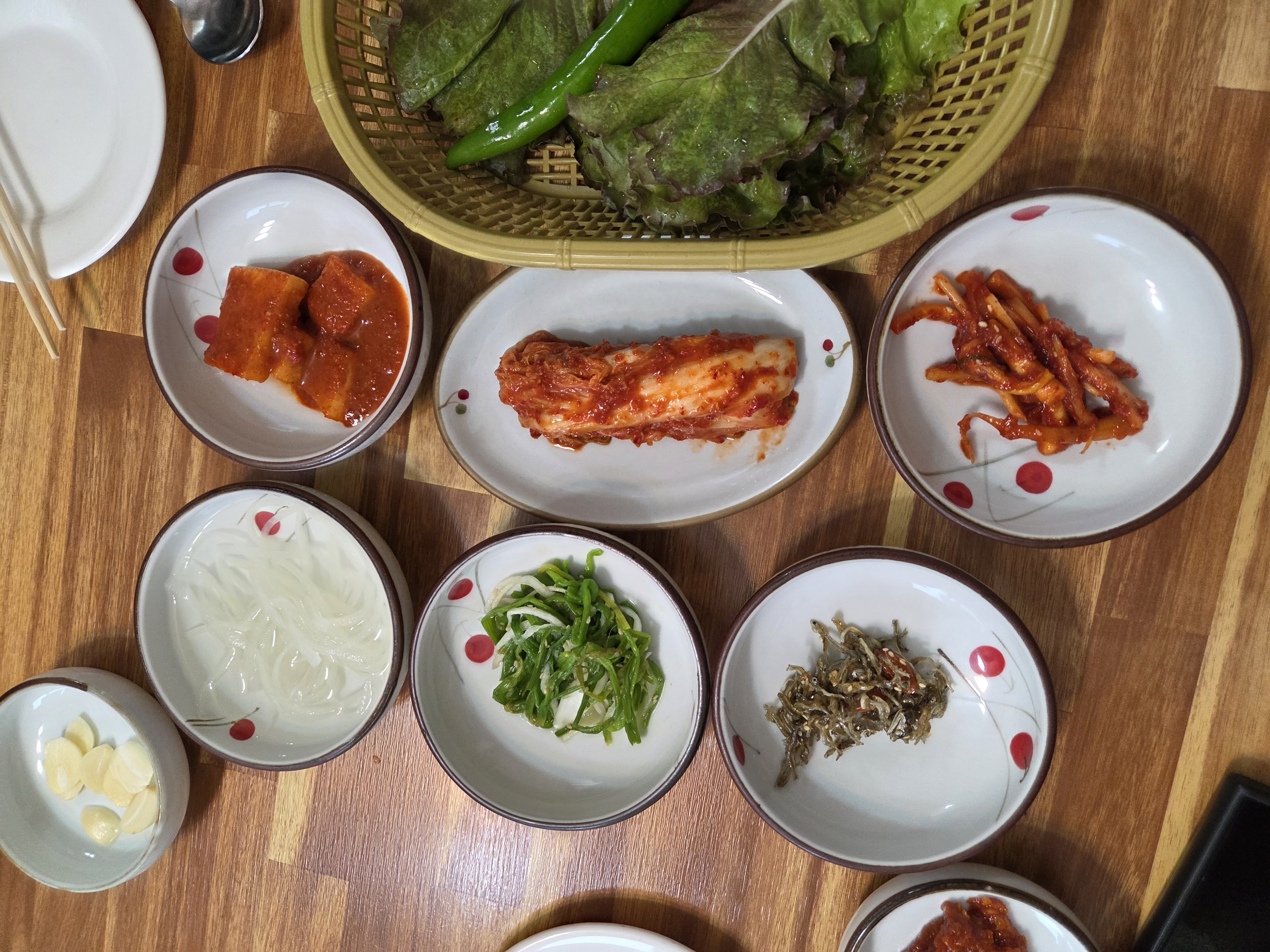 신식당 기본 반찬 상차림 김치 깍두기 고추무침 멸치볶음 상추와 고추 등