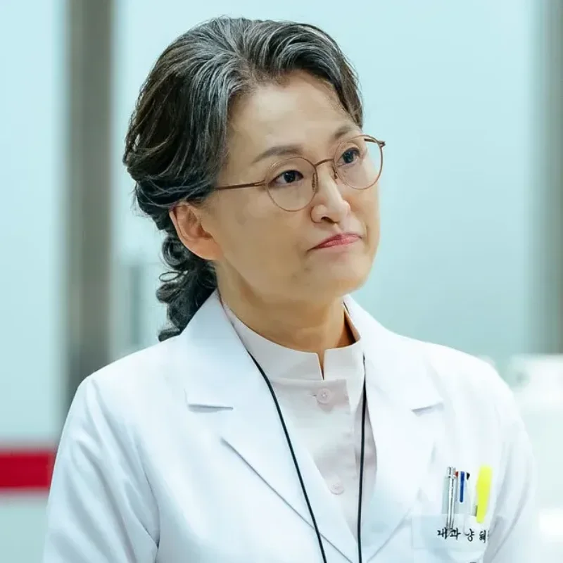 어느 병원을 배경으로 의사 가운을 입고 반백인 머리에 안경을 쓴 국민사형투표의 양혜진