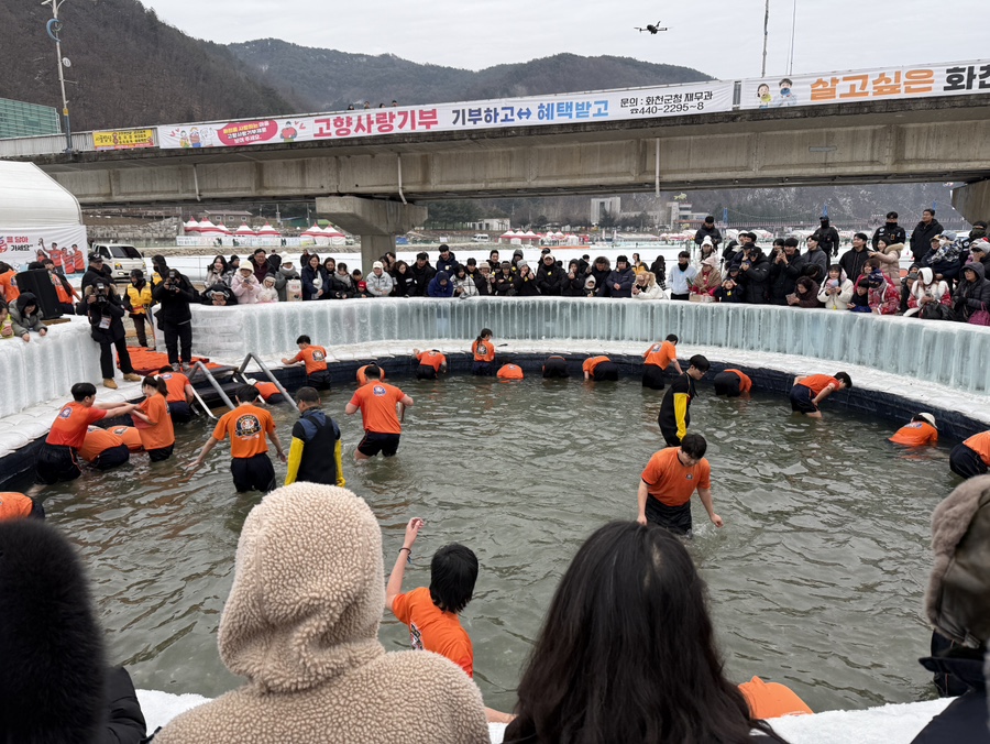 화천 산천어축제에서 참가자들이 얼음 수조에서 산천어를 맨손으로 잡는 체험을 즐기는 모습