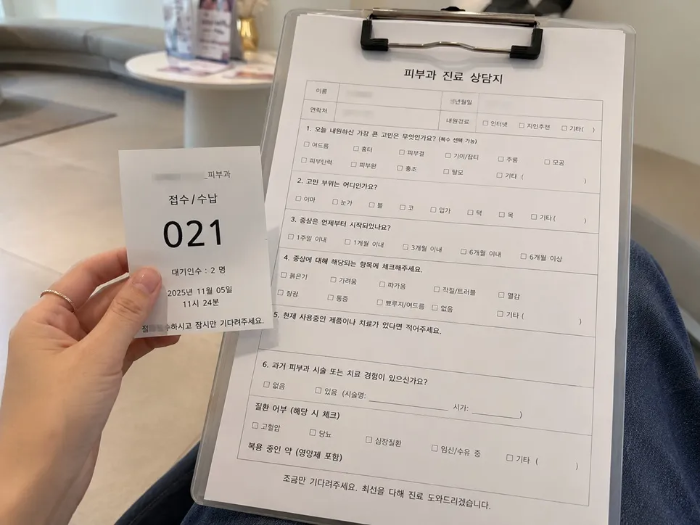 피부과 대기실에서 손에 들고 있는 대기표 067번과 그 아래로 보이는 상세히 작성된 피부 상담 문진표