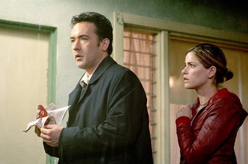 아이덴티티 존 쿠삭 에드와 레이 리오타가 폭우 속 모텔에서 긴장한 표정으로 서 있는 장면