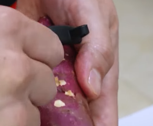 채칼로 고구마 껍질을 까고 있다.