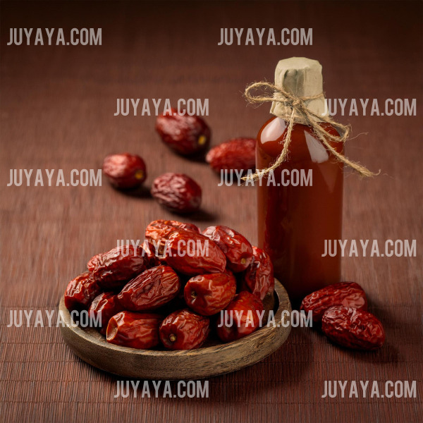 나무 접시에 담긴 말린 대추와 유리병에 담긴 대추 엑기스. 건강 음료로 활용 가능한 대추.