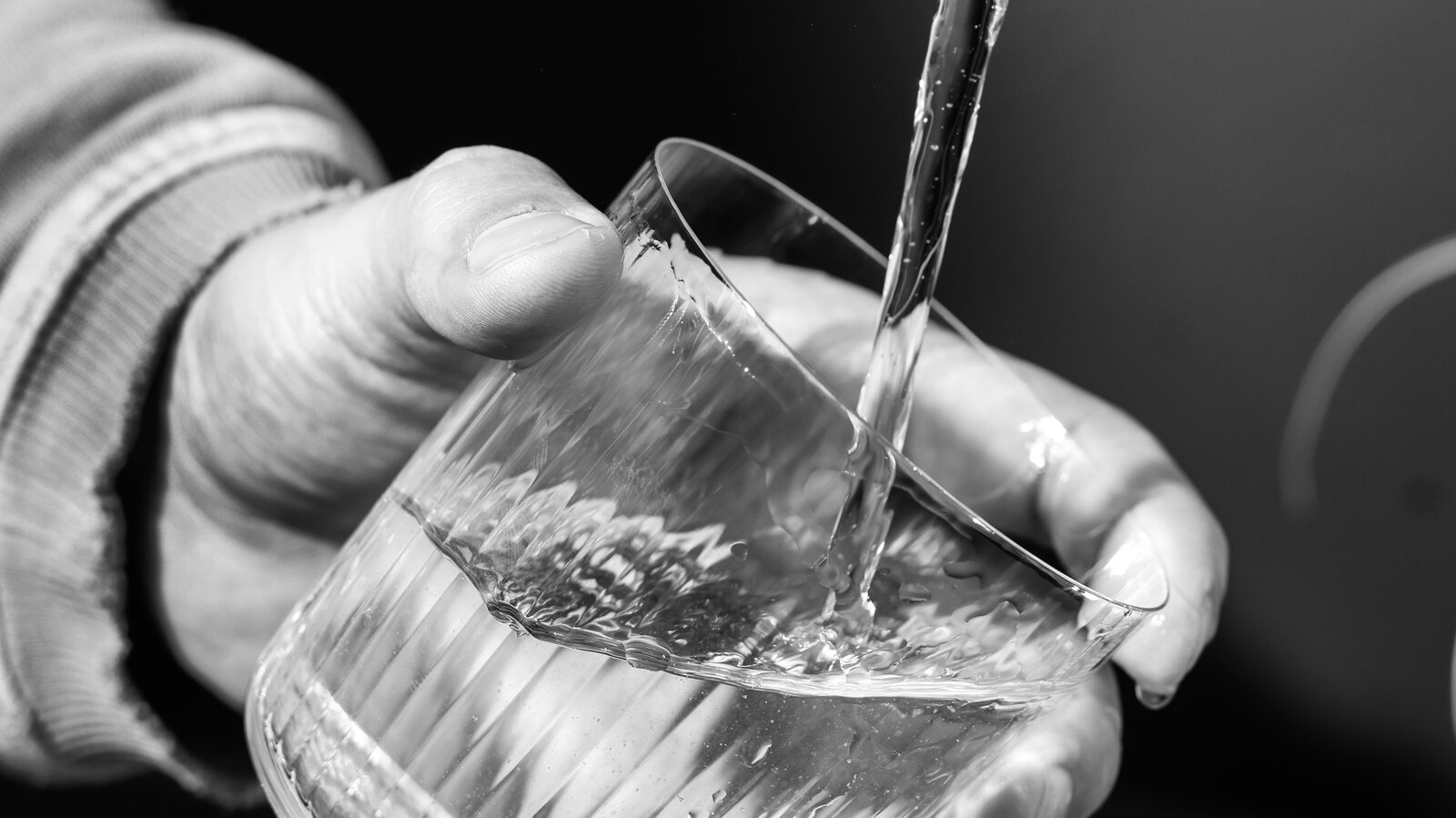 A modern kitchen with a refurbished water purifier, with clean water being poured into a glass