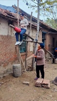 나무로-비계를-만들어-위에올라가-지붕을-수리하는-아주머니