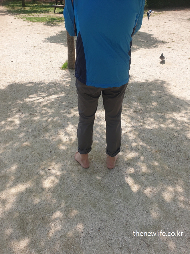 Man standing barefoot under the shade at the grounding zone of Children's Grand Park-어린이대공원 그늘 아래 맨발 걷기 구역에서 맨발로 서 있는 남성의 모습